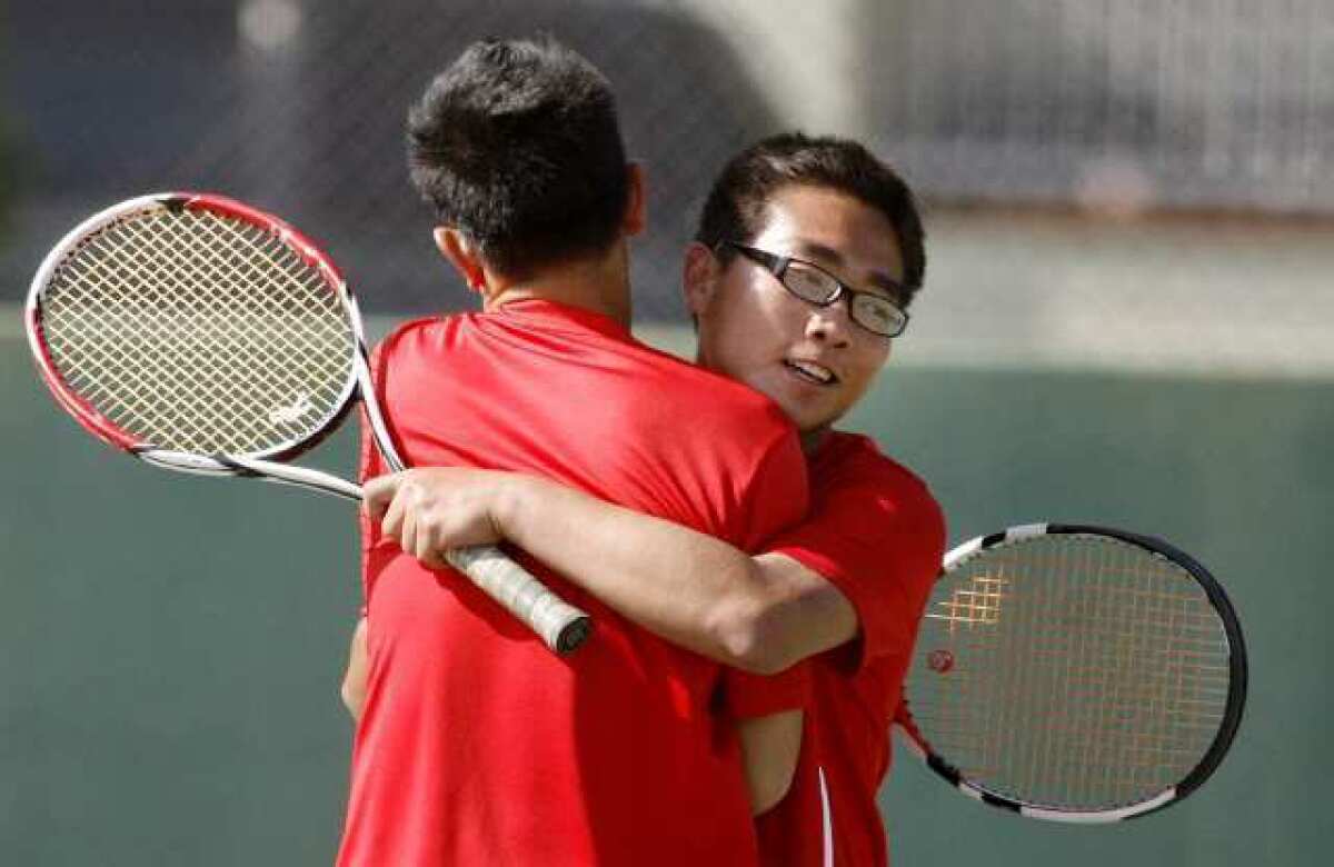 Burroughs' Kevin Hoang and Wen Yao Lin embrace after winning their second prelim match in a Pacific League boys doubles tennis prelims match at Pasadena High School on Monday, April 29, 2013. (Tim Berger/Staff Photographer)