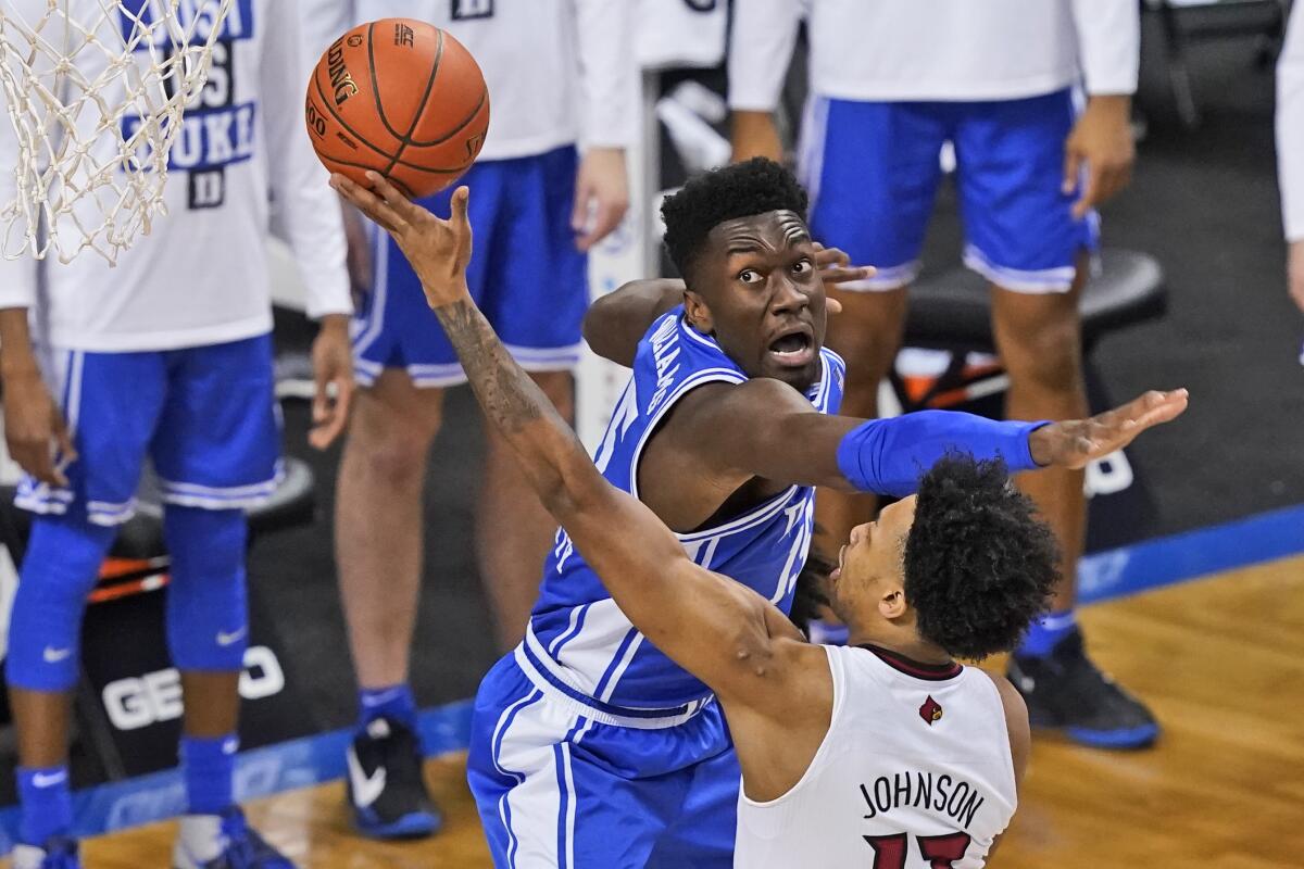 Duke center Mark Williams tries to block the shot of Louisville guard David Johnson during an ACC tournament game.
