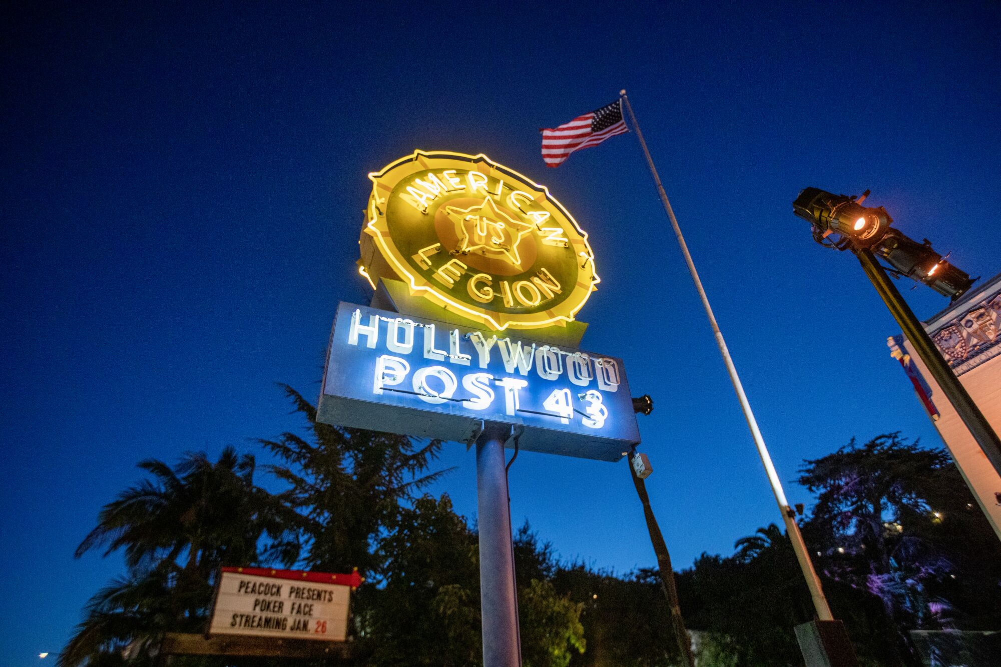 Neon sign reads "American Legion Hollywood Post 43" while a smaller sign says "Peacock presents Poker Face streaming Jan. 26"