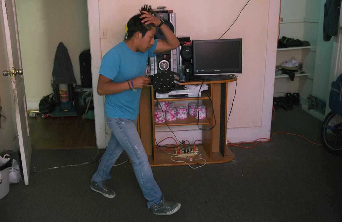 Belmont High student Gaspar Marcos rushes to get ready for work at his Westlake apartment.