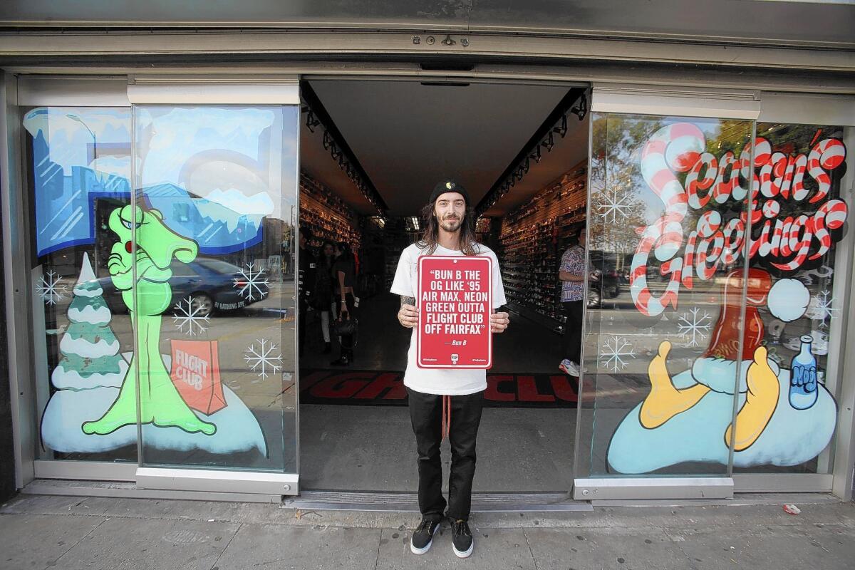 Tony Castillo, a street-art collector, stands at the entrance of Flight Club on Fairfax Avenue in L.A. where he spotted a sign, one of 45 across the city created and installed by artist Jason Shelowitz.