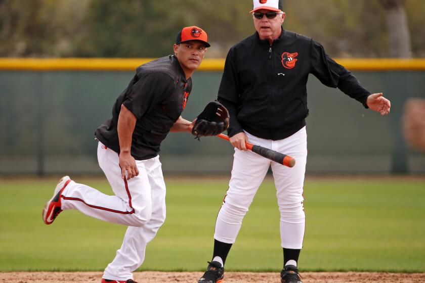 Newly acquired free agent Everth Cabrera takes instruction from Orioles Manager Buck Showalter during a spring training workout.