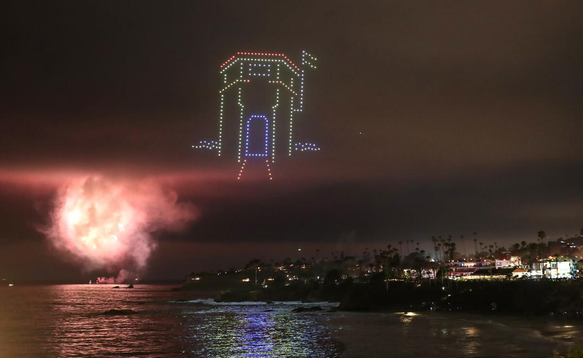 A group of drones take the shape of the Main Beach lifeguard tower as part of the Fourth of July drone show in Laguna Beach.