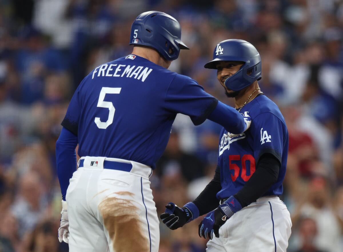 Mookie Betts celebrates with Dodgers teammate Freddie Freeman after hitting a solo home run.