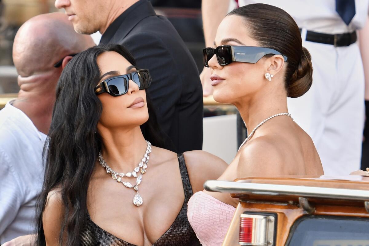 Kim and Khloé Kardashian both wear sunglasses, gowns and jewels onboard a Venice water taxi.