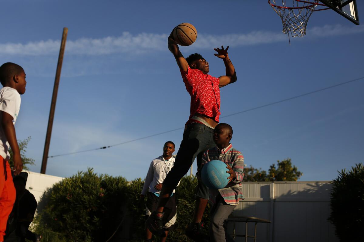 A duplex that is home to several family members has been a training ground for Compton's Sean Harlston. Here he takes flight while looking toward the basket.