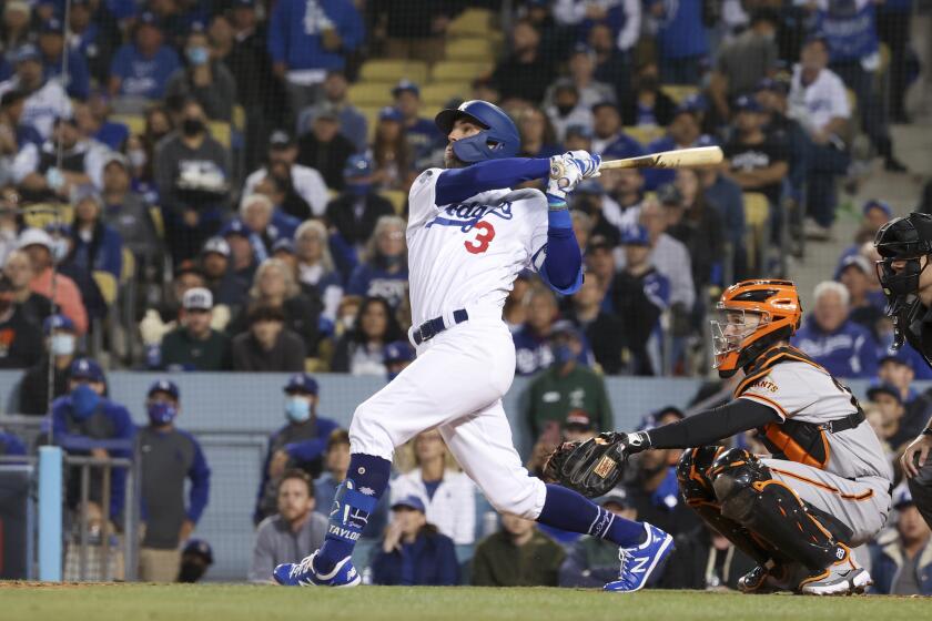 Los Angeles, CA - October 12: Los Angeles Dodgers' Chris Taylor follows through on a swing for a sacrifice fly ball to score Gavin Lux during the second inning in game four of the 2021 National League Division Series against the San Francisco Giants at Dodger Stadium on Tuesday, Oct. 12, 2021 in Los Angeles, CA. (Robert Gauthier / Los Angeles Times)