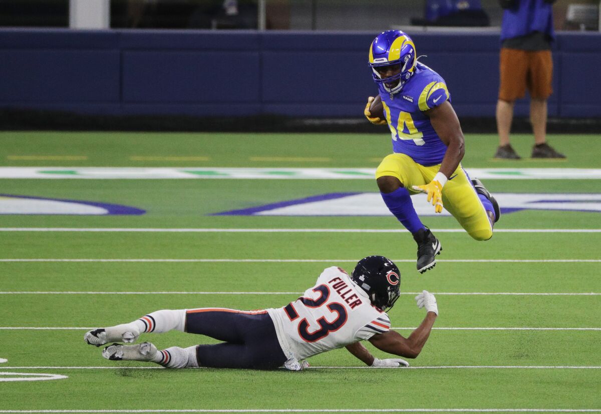 Rams running back Malcolm Brown leaps over Chicago Bears cornerback Kyle Fuller while holding the football.