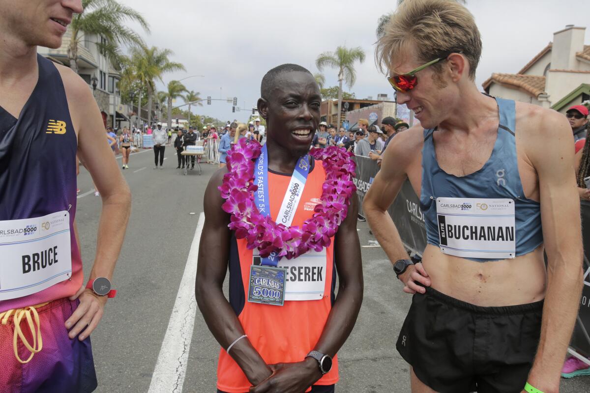 Reid Buchanan (right), talking with Carlsbad 5000 winner Ed Chesereck, has thrived since relocating to San Diego in 2016.