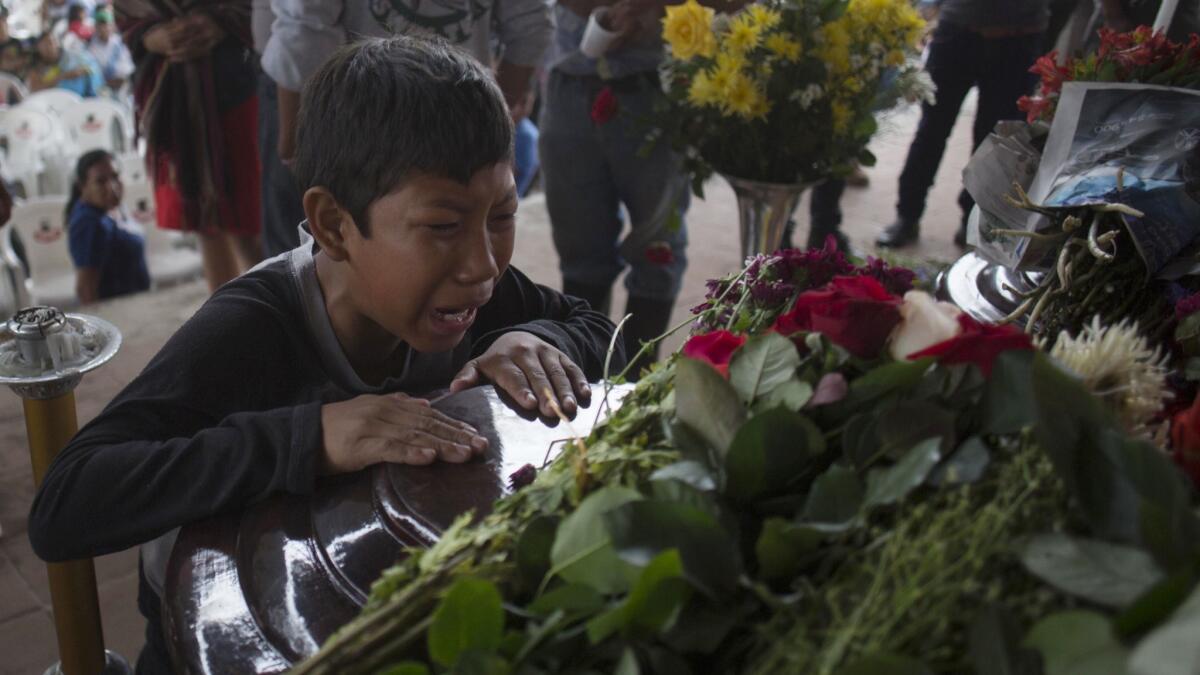 A youth cries over the coffin of Nery Otoniel Gomez Rivas, 17, whose body was pulled from the volcanic ash, during a wake in San Juan Alotenango, Guatemala, on June 4, 2018.