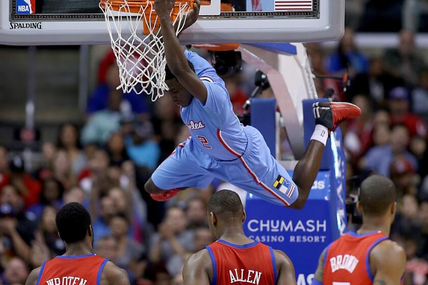 Darren Collinson hangs on the rim after cutting through the Philadelphia 76ers defense for a dunk during the Clippers' 123-78 victory at Staples Center.