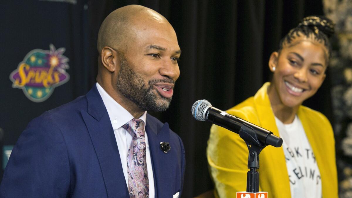 Derek Fisher, the Sparks' new head coach, is joined by two-time WNBA most valuable player Candace Parker during a news conference.