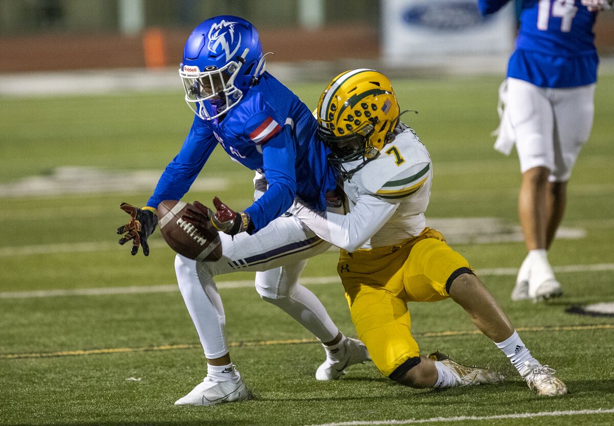 Edison's Logan Gregory knocks the ball loose from Los Alamitos' Ethan O'Connor during a Sunset League game on Thursday.