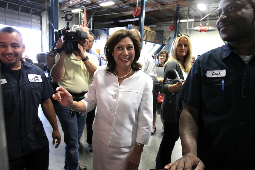 Then-U.S. Secretary of Labor Hilda Solis jokes with students in the Santa Clara Valley Transportation Authority hybrid technology training program in 2011.