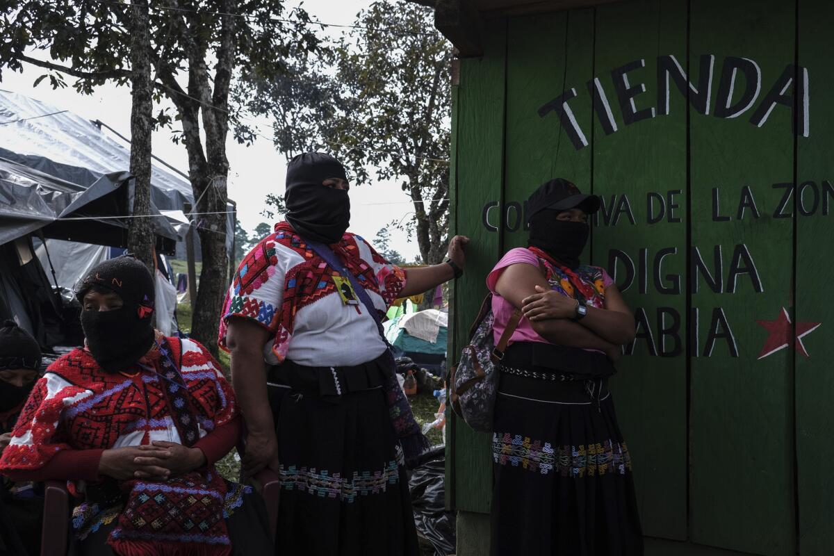 Organizadoras enmascaradas del Segundo Encuentro Internacional de Mujeres que Luchan, se paran a la entrada de una tienda donde se reciben donaciones, durante el Segundo Encuentro Internacional de Mujeres que Luchan, organizado por las mujeres del Ejército Zapatista de Liberación Nacional (EZLN), en el Caracol de Morelia, municipio de Altamirano, estado de Chiapas, México, el domingo 29 de diciembre de 2019.