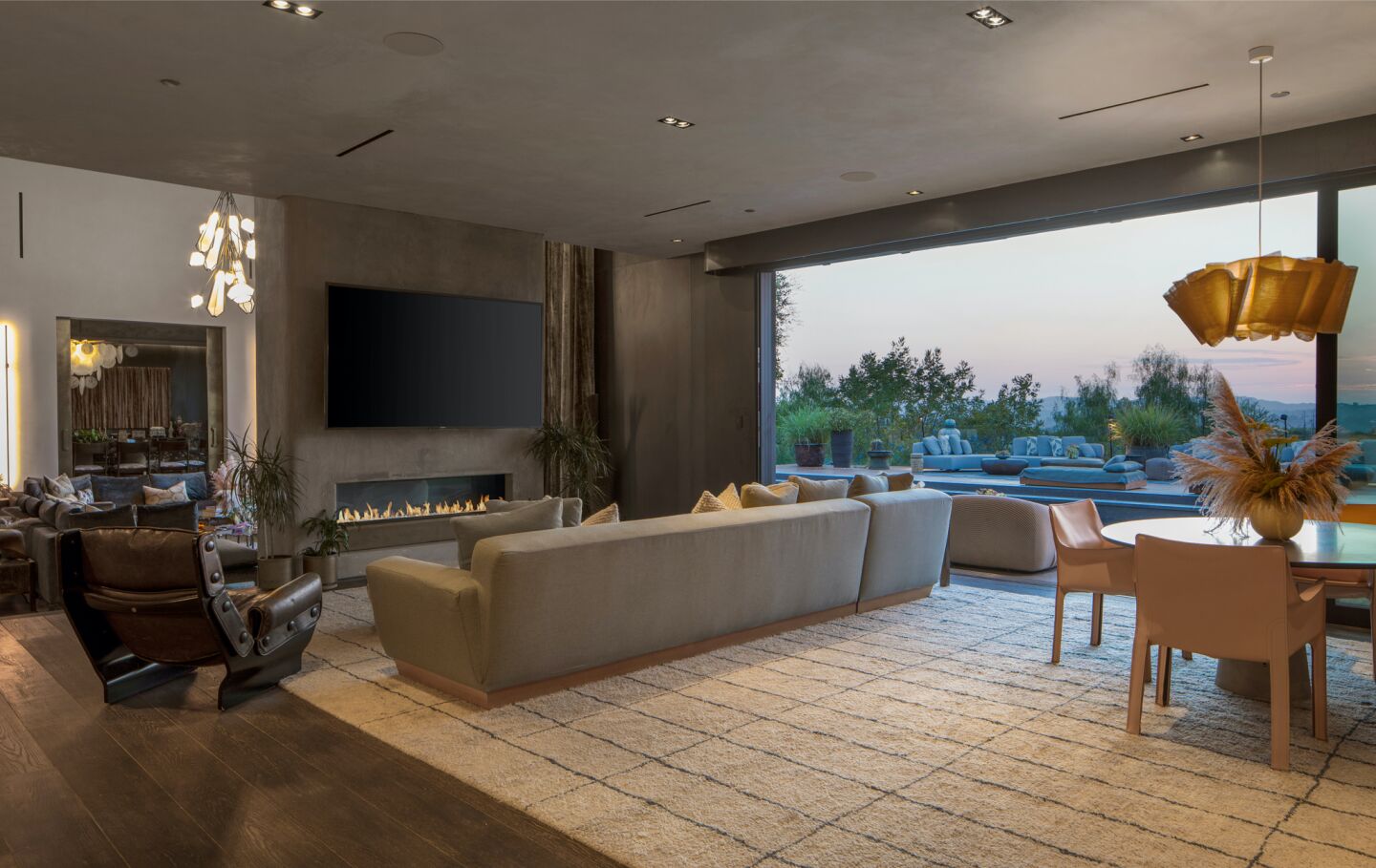 The living room has ceiling to floor windows and modern furnishings.