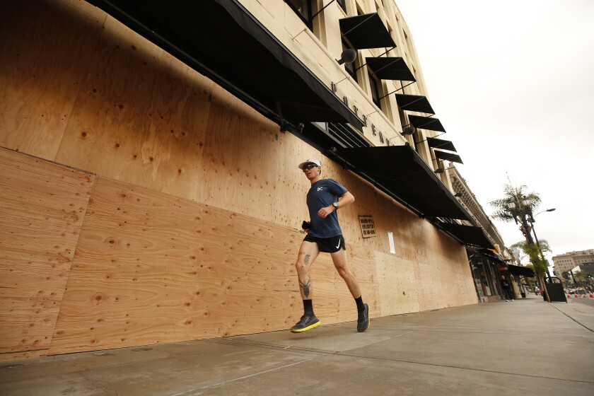 A runner jogs past the Pottery Barn store on Colorado Boulevard in Pasadena on Thursday morning.