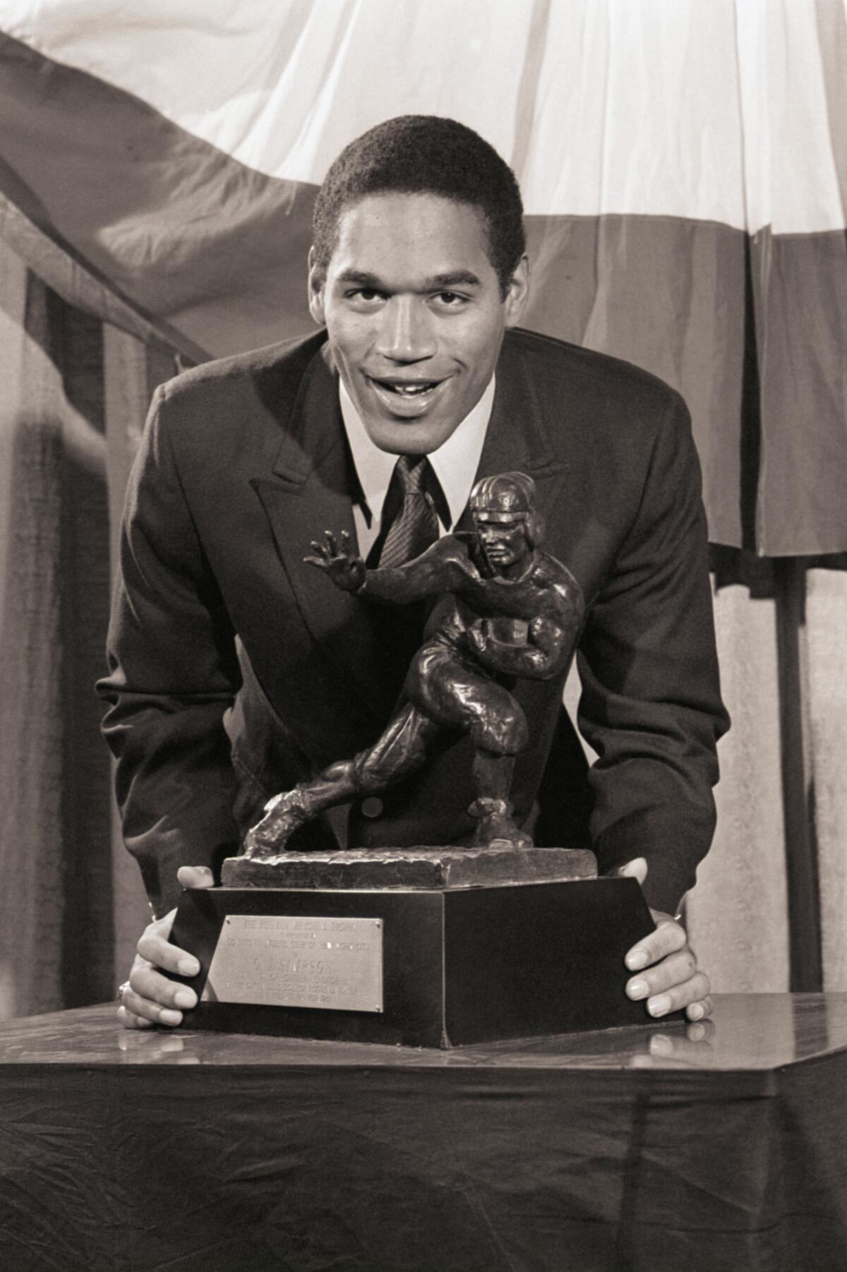 USC running back O.J. Simpson leans over the Heisman Trophy he received on Dec. 5, 1968.