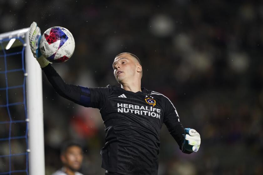 Galaxy goalkeeper Novak Micovic jumps to grab the ball during a match against Real Salt Lake 