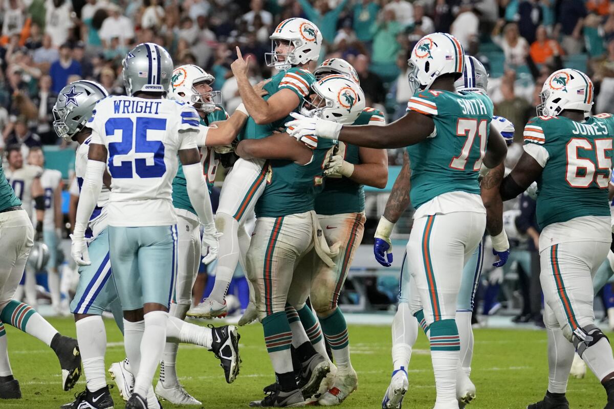 Dolphins kicker Jason Sanders, center, celebrates after kicking the winning field goal against the Cowboys.
