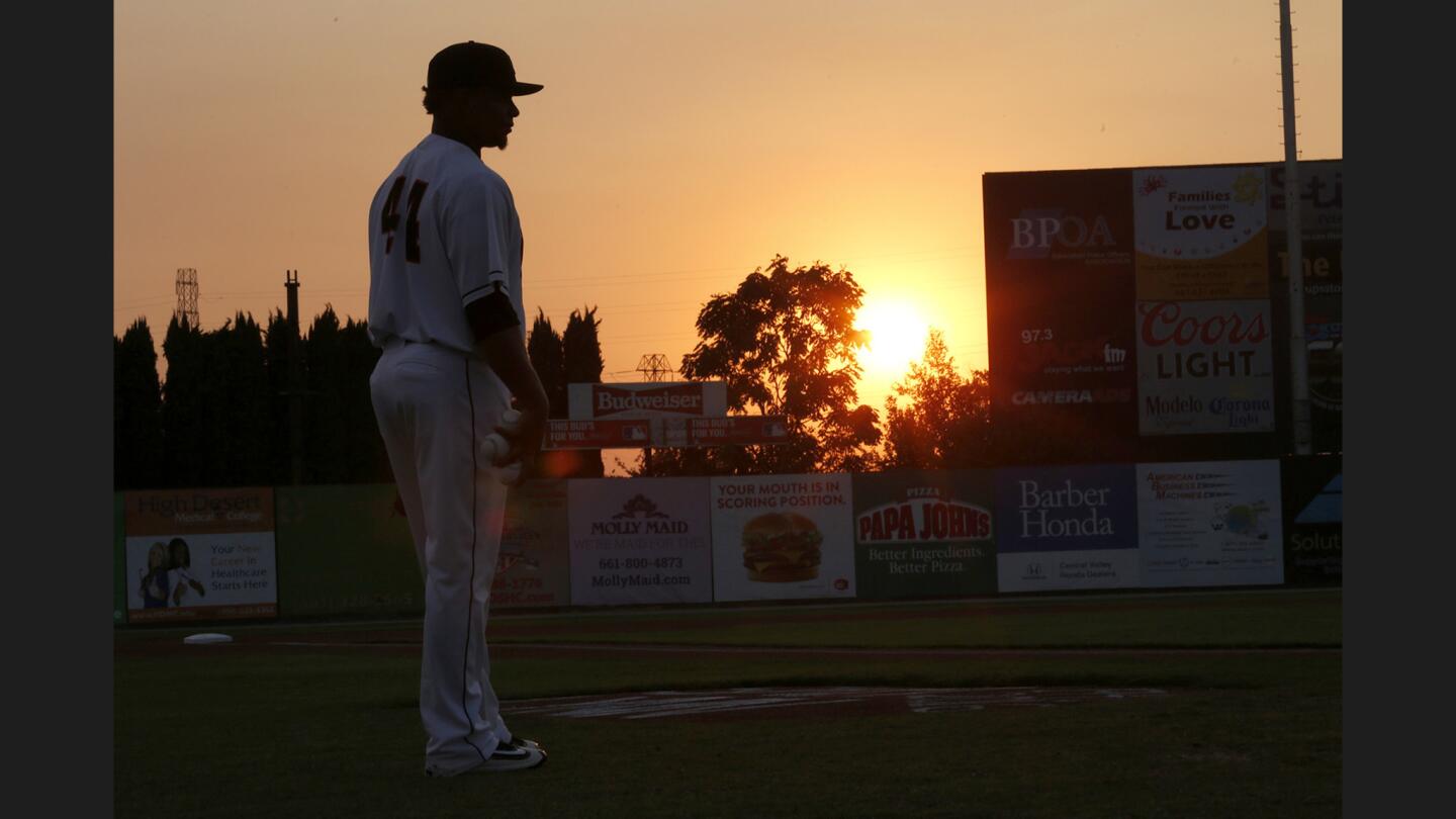 The sun slowly sets over Sam Lynn Ballpark beyond Bakersfield Blaze player Ramon Moria before a game against the Stockton Ports on Aug. 26, 2016.