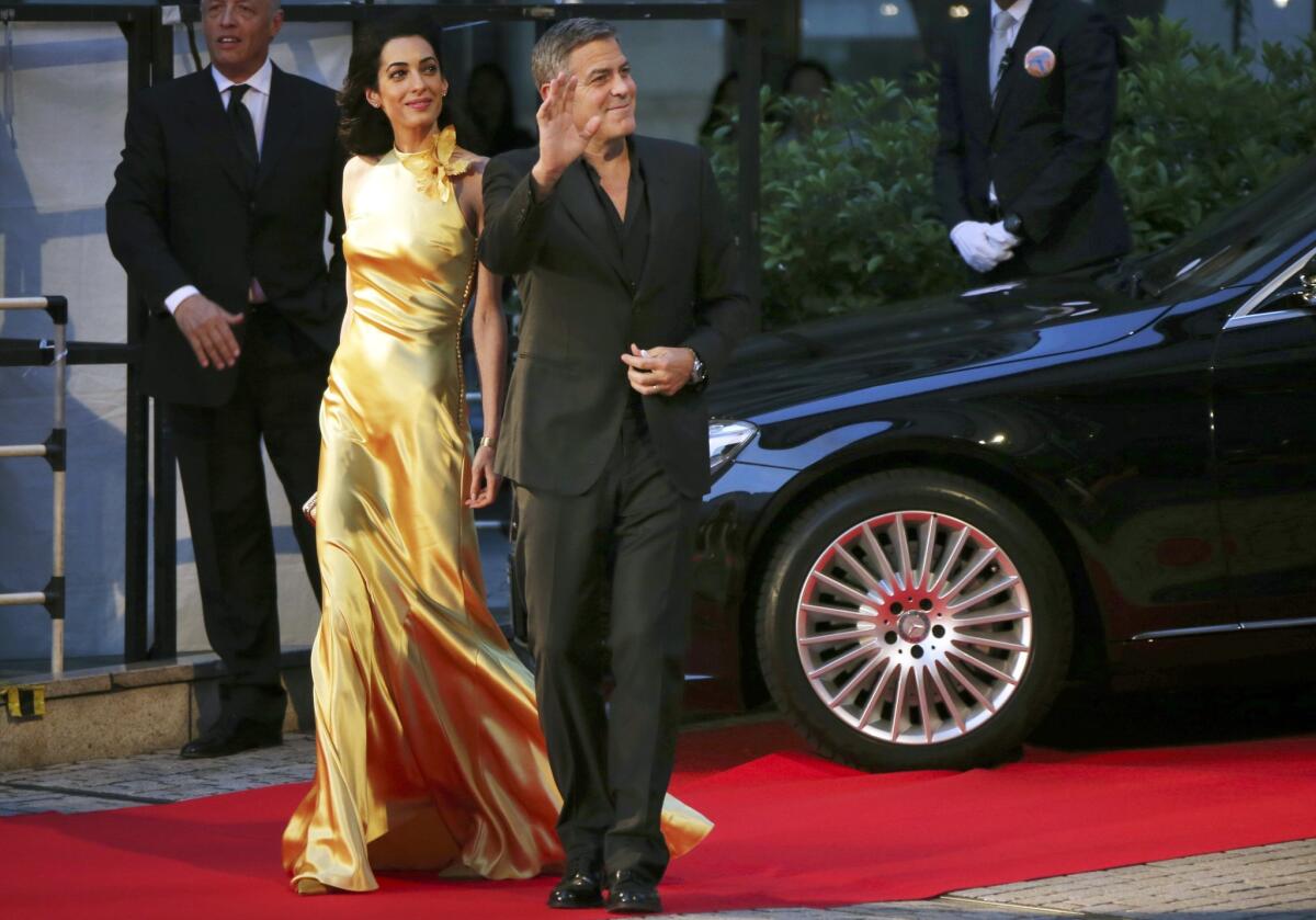 George Clooney and his wife, Amal, arrive for the Japan premiere of Disney's latest film, "Tomorrowland," in Tokyo on Monday.