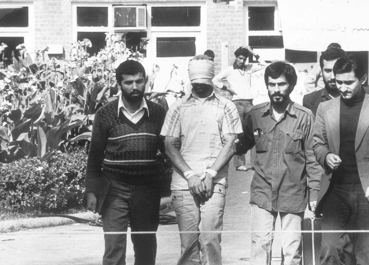 FILE - In this Nov. 8, 1979 file photo, one of the hostages held at the U.S. Embassy in Tehran, Iran is shown to the crowd by Iranian students. Forty years ago on Nov. 4, 1979, Iranian students overran guards to take over the U.S. Embassy in Tehran, starting a 444-day hostage crisis that transfixed America. (AP Photo, File)