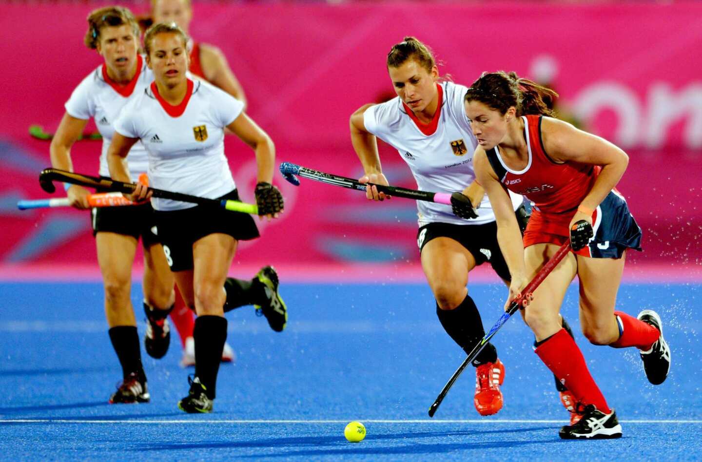 Team USA's Rachel Dawson, right, runs past defenders from Germany during a preliminary round match at the Riverbank Arena.