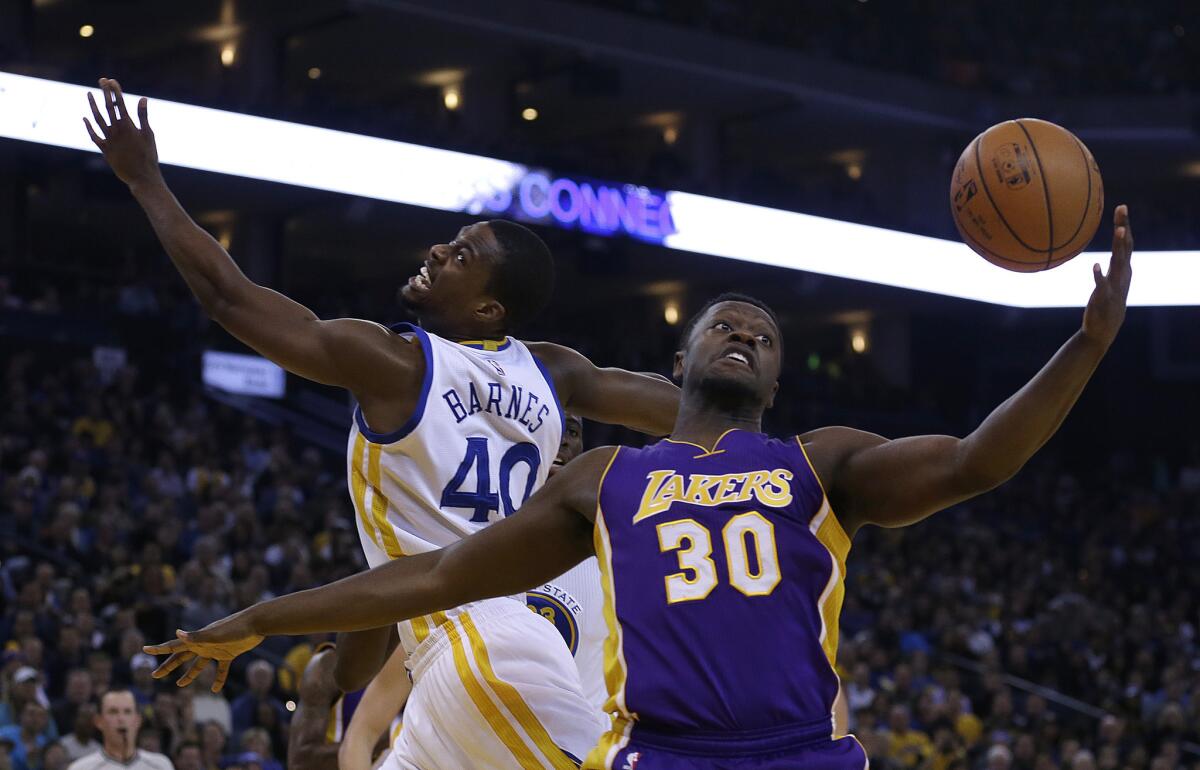 Los Angeles Lakers' Julius Randle, right, and Golden State Warriors' Harrison Barnes reach for a rebound during the first half on Thursday.