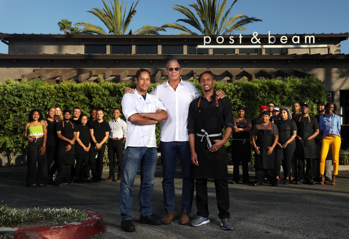 Restaurateur Brad Johnson, center, chef-owner John Cleveland, right, and chef-consultant Govind Armstrong, left, gather with the staff at Post & Beam restaurant in Baldwin Hills.