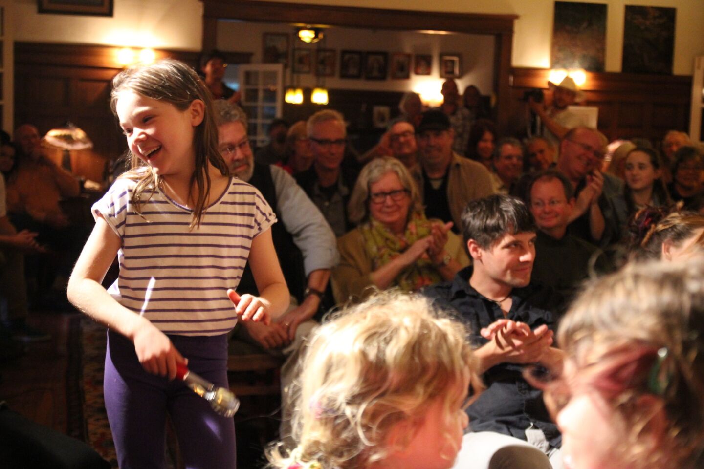 Members of the audience will sometimes join — clapping, dancing and clogging. This young girl plays the spoons.