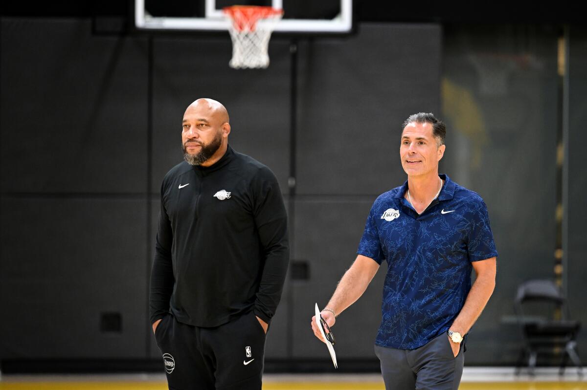 Lakers coach Darvin Ham, left, and general manager Rob Pelinka take part in a news conference.