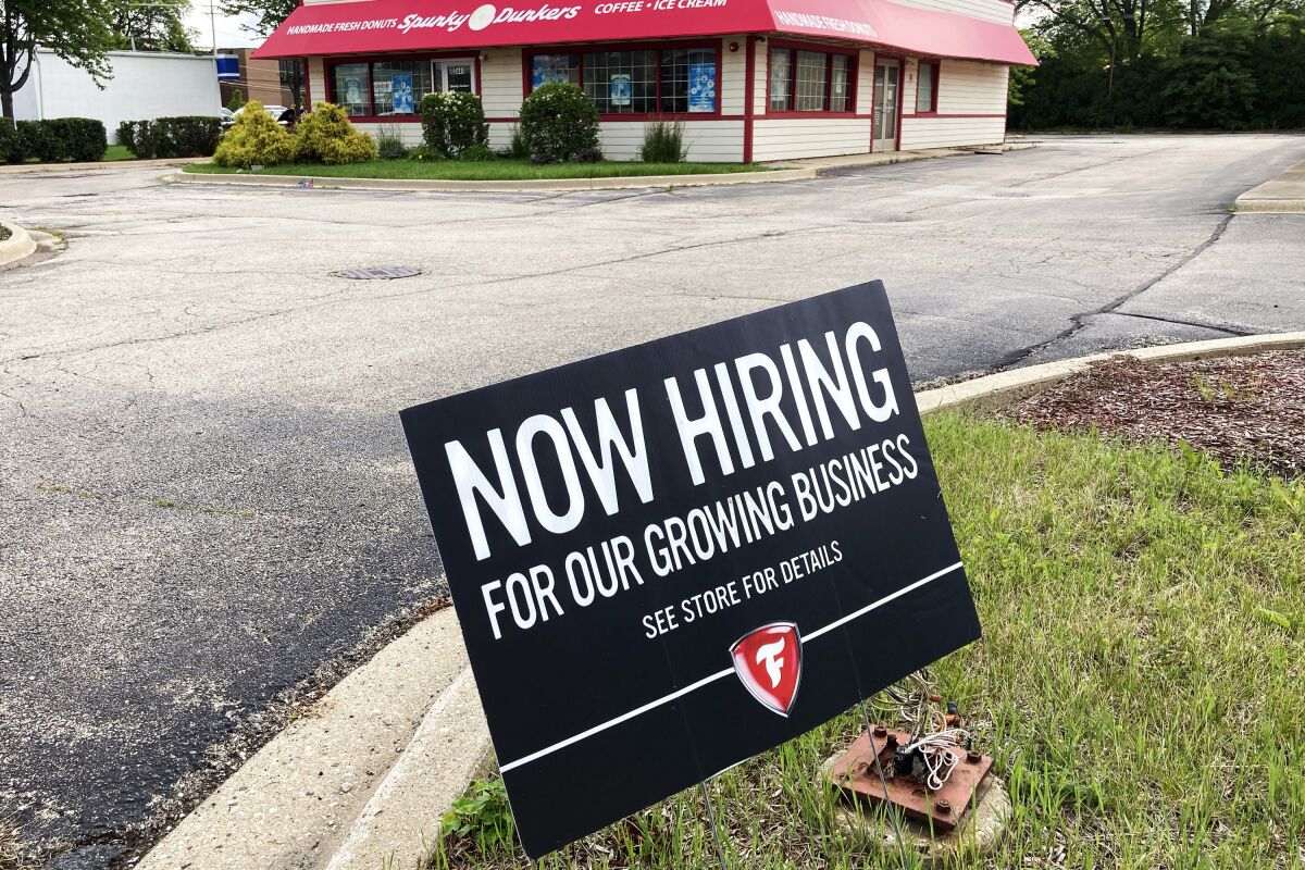 A hiring sign is displayed at Firestone Complete Auto Care store in Arlington Heights, Ill., Wednesday, June 30, 2021. The U.S. job market is storming into summer: Job creation and wages rose sharply in June, and more and more Americans are confident enough to quit their jobs and look for something better. The Labor Department reported Friday, July 2 that employers added 850,000 jobs last month, most since August.(AP Photo/Nam Y. Huh)