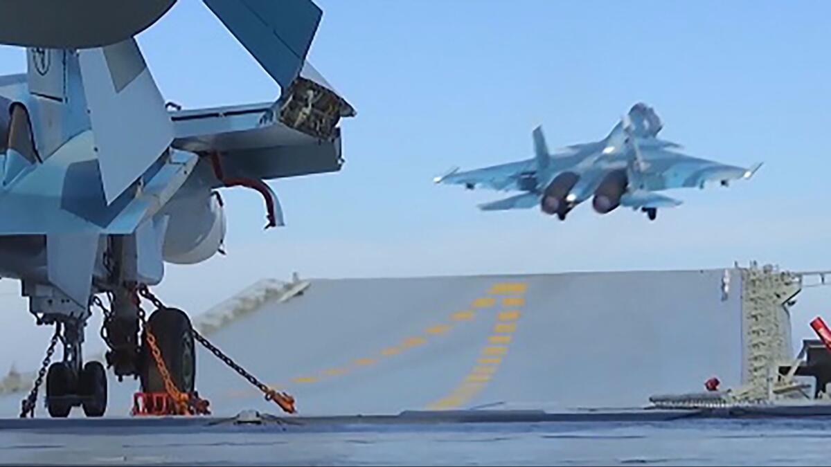 In an image released by the Russian defense ministry, a jet takes off from the aircraft carrier Admiral Kuznetsov in the eastern Mediterranean on a mission against Syrian rebels.