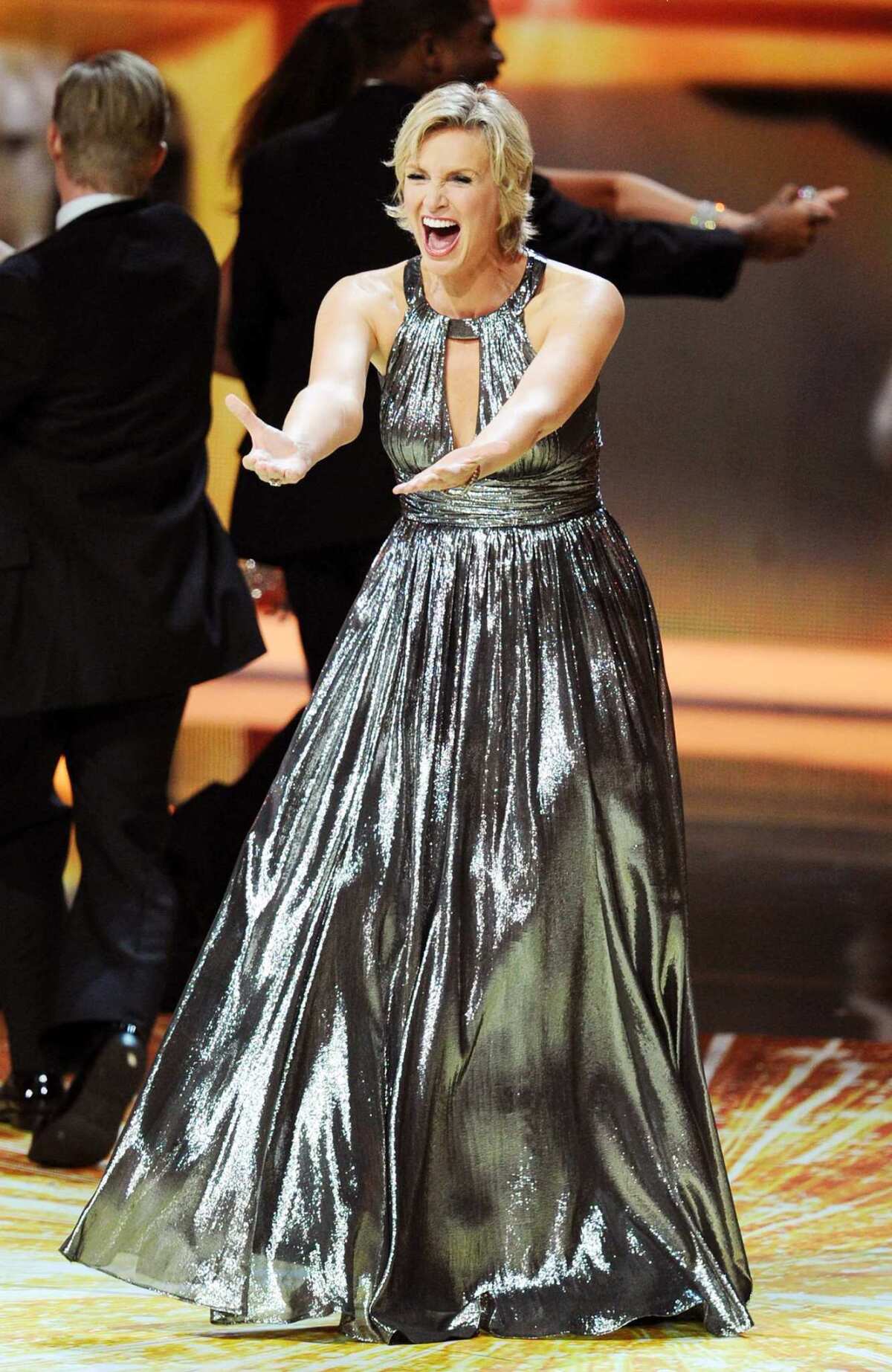 Host Jane Lynch performs onstage during the 63rd Annual Primetime Emmy Awards in a dress by David Meister.