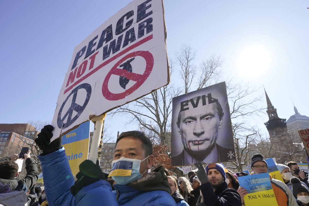 Demonstrators rally in support of Ukraine on the street with signs. 