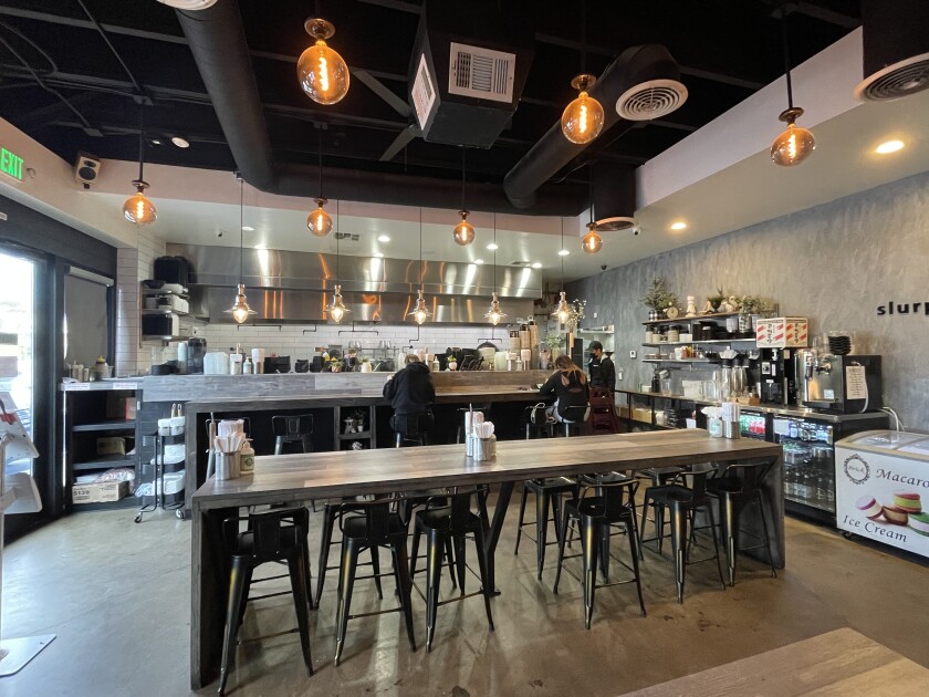 The dining area and counter inside Slurpin Ramen Bar on Bristol Street in Costa Mesa.