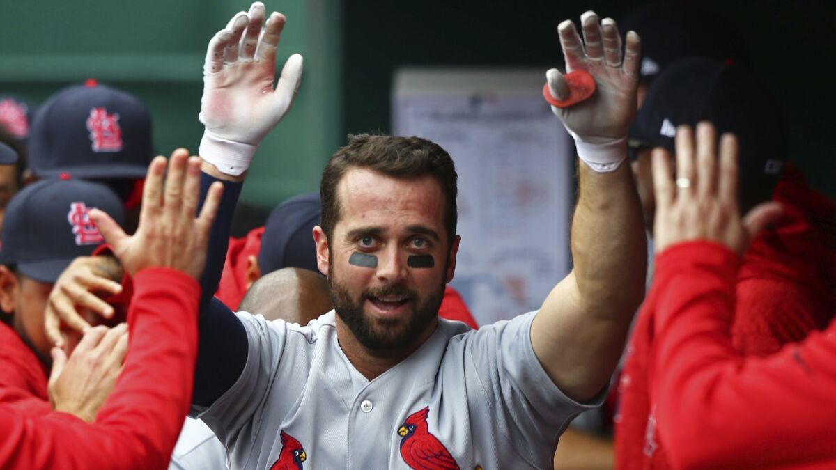The Cardinals' Greg Garcia high fives teammates after hitting a home run in the fourth inning of a baseball game against the Cincinnati Reds, Saturday, April 14, 2018, in Cincinnati. The Cardinals won 6-1.