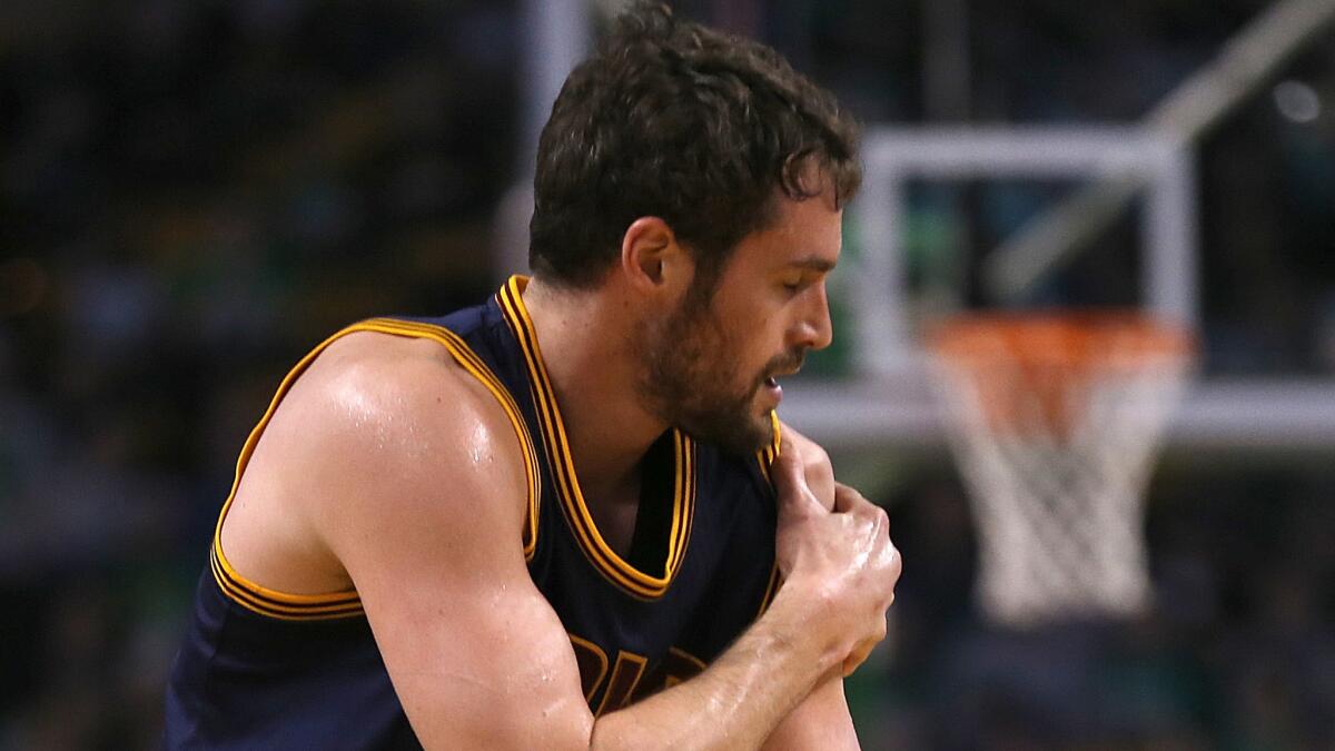 Cleveland Cavaliers forward Kevin Love runs off the court after suffering a dislocated shoulder during the first quarter of a 101-93 victory over the Boston Celtics in Game 4 of the Eastern Conference quarterfinals on Sunday.