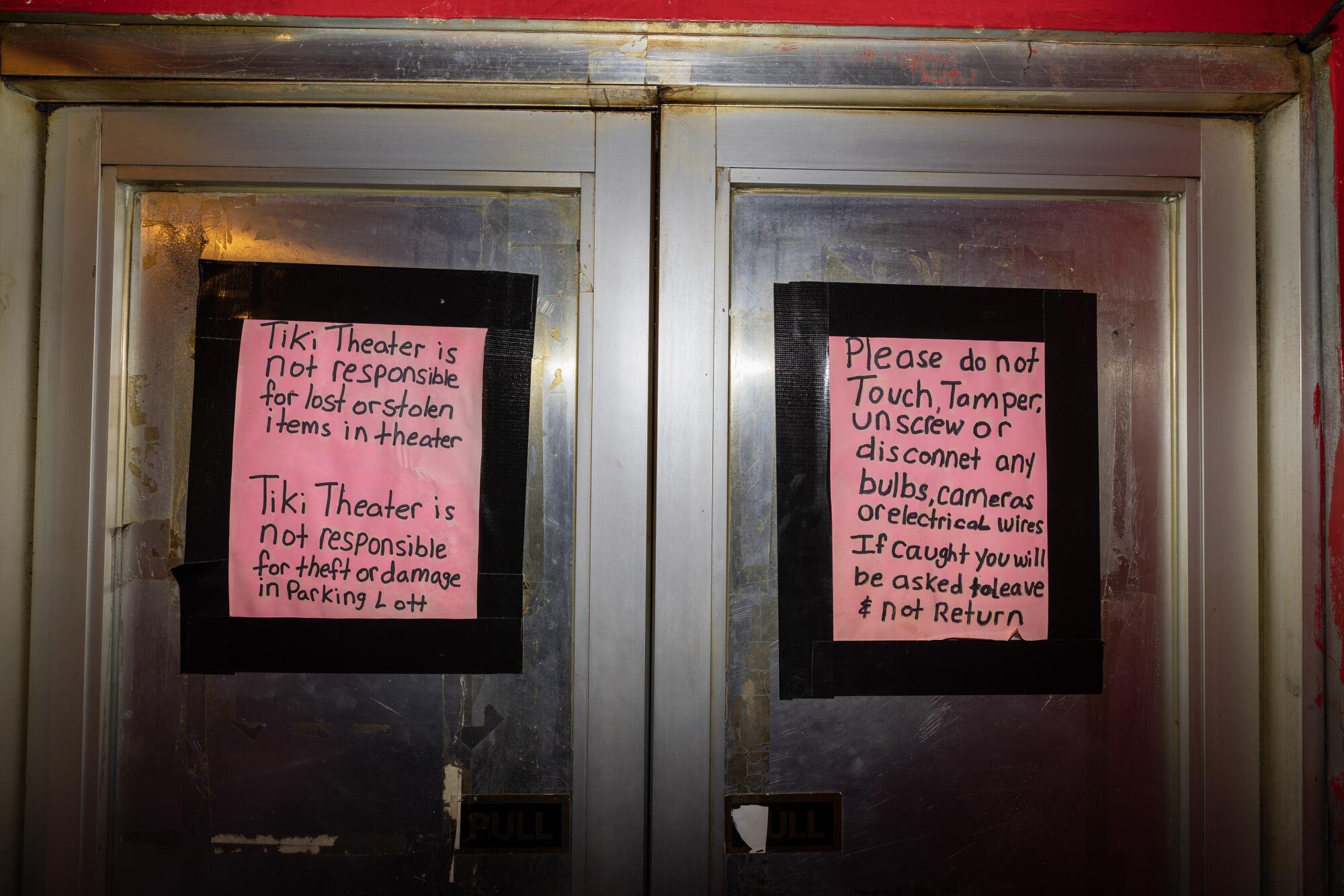 Signs inform patrons on the front doors to the Tiki Theater.
