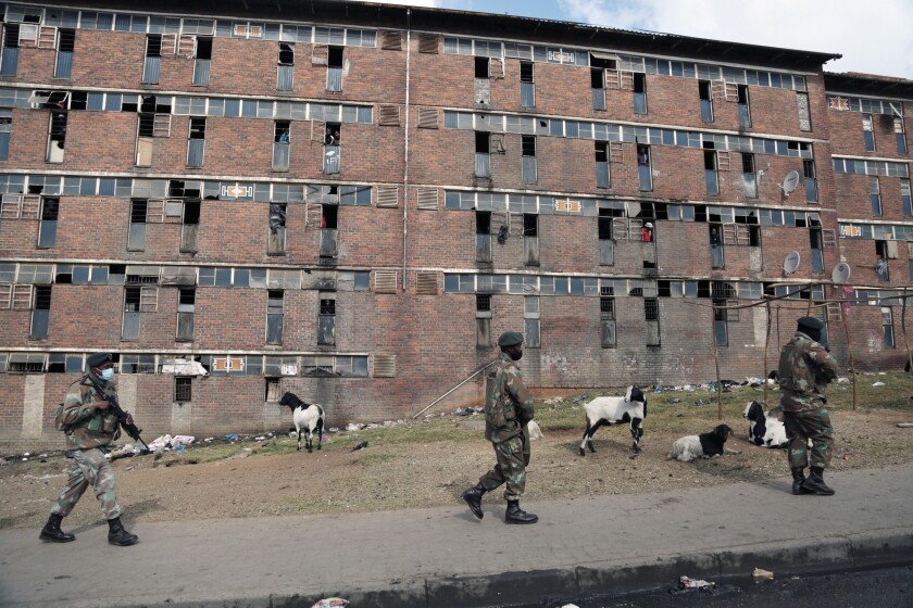 South African Defence Force soldiers on patrol alongside the male single sex hostels in Alexandra Township, north of Johannesburg, Thursday, July 15 2021. The army has begun deploying 25,000 troops to assist police in quelling the weeklong riots and violence sparked by the imprisonment of former President Jacob Zuma. (AP Photo)