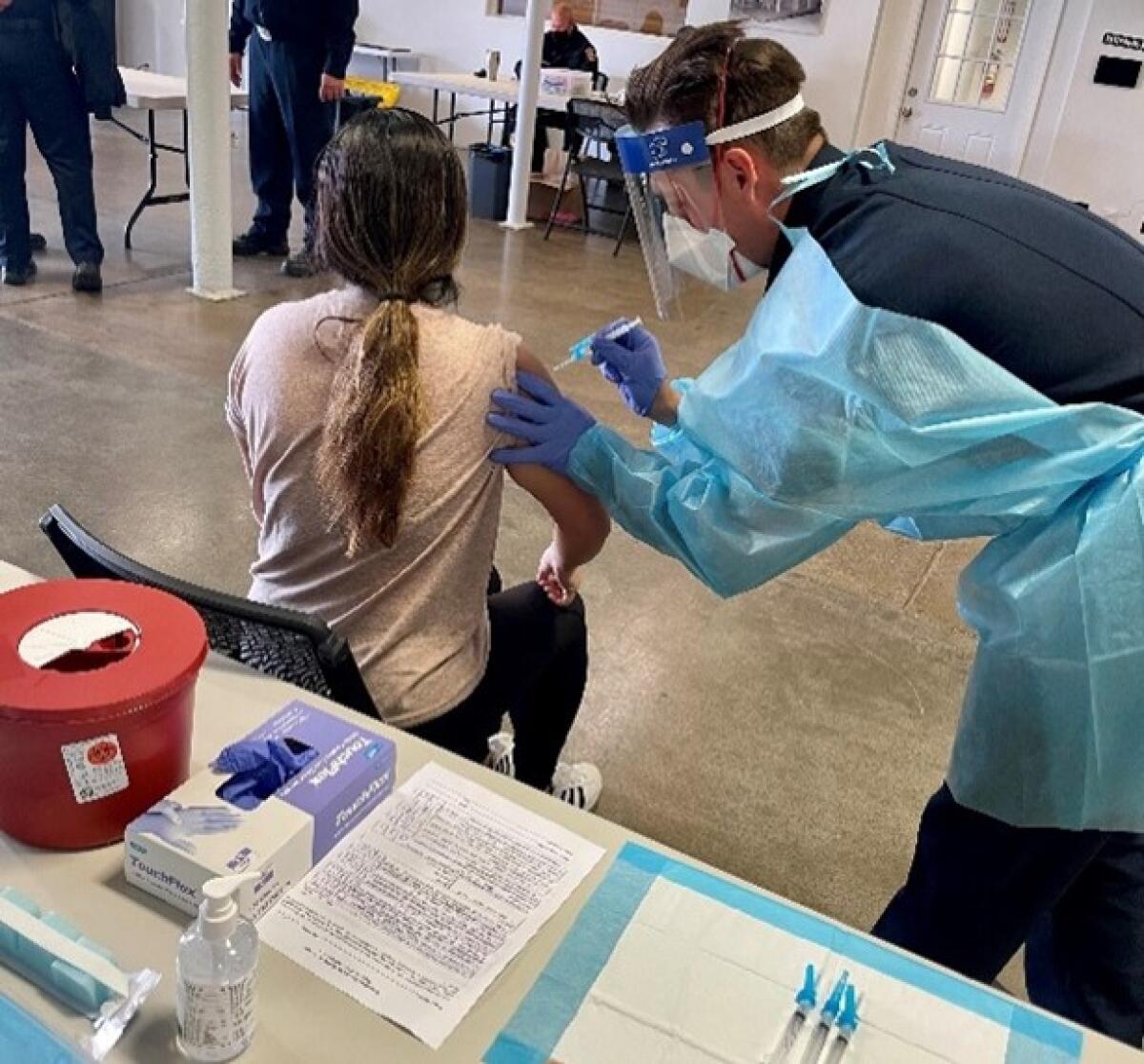 An Encinitas firefighter preparing to give a vaccine.