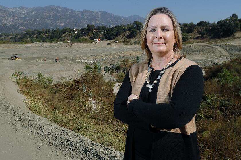 LCUSD parent, Flintridge Sacred Heart Academy teacher and co-founded LCF 4 Healthy Air Elizabeth Krider with the clean-up area of Devil's Gate Dame on Tuesday, October 29, 2019. Krider single-handedly put new research data on diesel truck emissions before county officials before the start of the Devil's Gate Dam sediment removal project and talked to county and state officials and, as a result, created a lot of changes in methodology and procedures that could set a precedent for how large-scale projects are conducted in the future.
