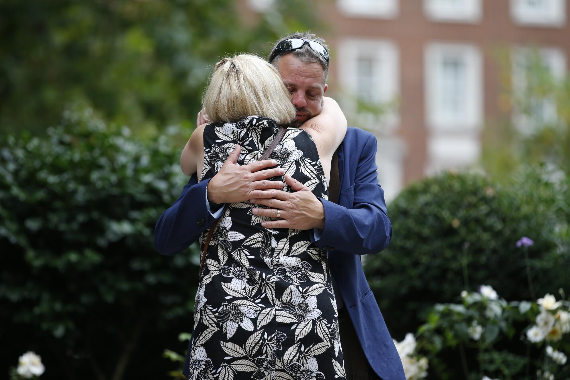 A man and woman embrace at a garden