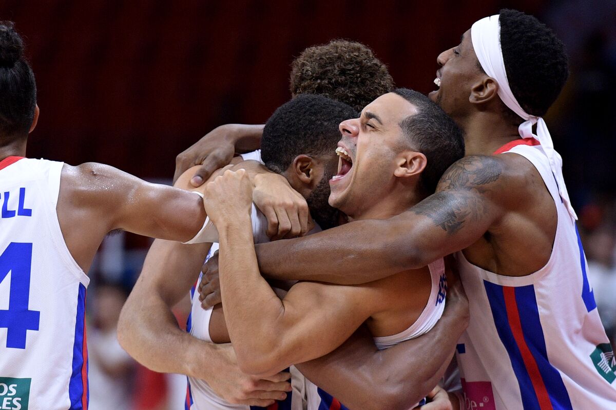 Puerto Rico's Angel Rodriguez, center, celebrates with teammates after a win over Tunisia