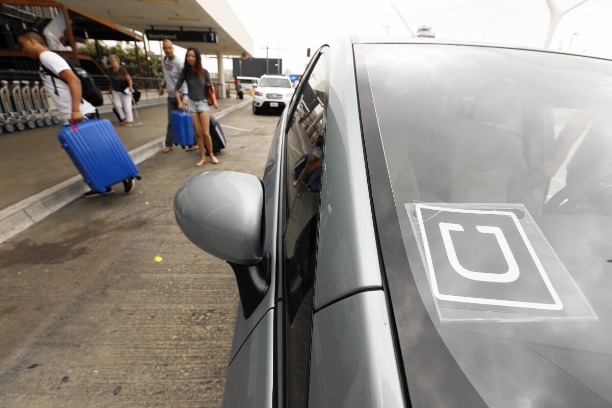 Passengers get an Uber ride to LAX. The L.A. City Council has acted to let Uber drivers pick up passengers as well.