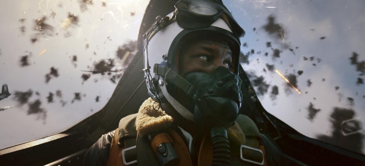 A man looks at enemy fliers from the cockpit of a Korean War fighter in a scene from "Devotion."