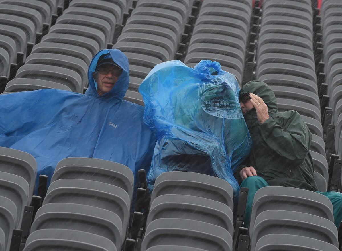 Fans are pelted by heavy rain as they wait for the qualifying session of the United States Formula One Grand Prix at the Circuit of the Americas in Austin, Texas, on Saturday. More rain is expected through the weekend.