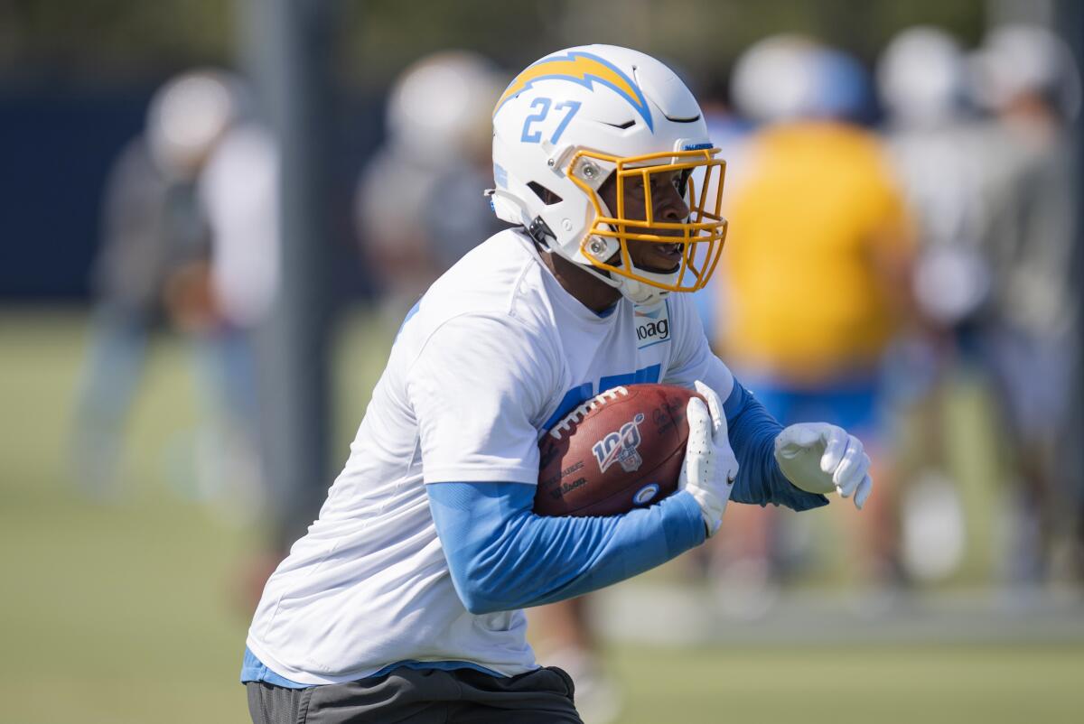 Chargers running back Joshua Kelley carries the football during a camp drill.