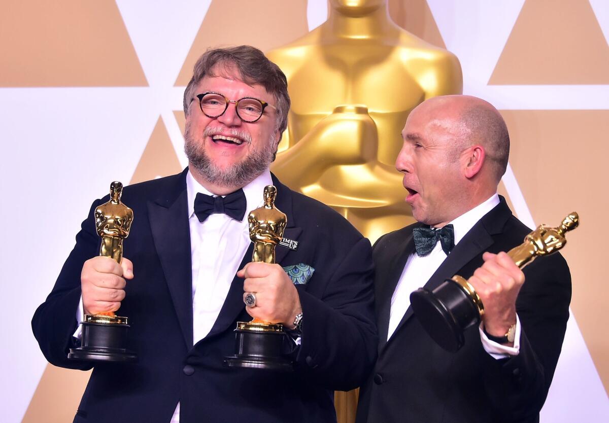 Producer and director Guillermo del Toro, left, and producter J. Miles Dale pose in the press room of the 90th Academy Awards.